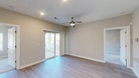 Located at 7011 Star Oaks Ln in Charlotte, NC, this well-appointed two-bedroom, two-bathroom home offers a thoughtfully designed single-floor layout. The open living area is bright and inviting, featuring light hardwood-style flooring, neutral warm-toned walls, recessed lighting, and a stylish ceiling fan. Sliding glass doors lead directly to a private balcony, flooding the space with natural light and providing outdoor views.

The kitchen is a standout feature, showcasing crisp white shaker cabinetry, granite countertops, a peninsula with an undermount sink, a subway tile backsplash, and a full suite of stainless steel appliances including a refrigerator, electric range, and microwave.

Both bedrooms are carpeted for comfort and include ceiling fans, large windows with blinds for natural light and privacy, and generous closet space with double-door closets. The primary bathroom is designed with accessibility in mind, featuring grab bars, a granite-topped vanity, and hardwood-style flooring. The second bathroom offers a full tub and shower combination with clean white surround finishes.

With four closets throughout, this home provides ample storage. The overall aesthetic is clean, modern, and move-in ready.