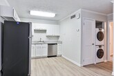 Located at 700 W Magnolia Ave in Auburn, Alabama, this single-floor unit offers a clean, updated interior with a cohesive design throughout. The kitchen is a standout feature, equipped with stainless steel appliances including a range, microwave, and dishwasher, complemented by classic white shaker cabinetry and granite countertops. Light hardwood-style flooring runs throughout the space, lending warmth and continuity to every room. Crown molding adds a polished finishing touch across the interior. The living and dining area is bright and open, benefiting from natural light through a large window with blinds, and features a ceiling fan for added comfort. The layout flows efficiently from the main living area into the kitchen, bathroom, and bedroom. The bedroom is a comfortable, well-proportioned room with its own ceiling fan and natural light from a window. The bathroom continues the granite countertop aesthetic seen in the kitchen, with matching cabinetry and a clean, neutral palette. A hallway connects the rooms, providing practical separation between living spaces. The overall ambiance is light, neutral, and move-in ready, reflecting thoughtful updates throughout.