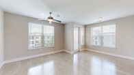 Located in Winter Park, Florida, this well-designed single-story home offers three bedrooms, two bathrooms, and a thoughtfully organized layout across a comfortable footprint. The open-concept living, dining, and kitchen area forms the heart of the home, bathed in natural light from multiple large windows. The kitchen is a standout feature, showcasing rich dark wood cabinetry, stainless steel appliances, pendant lighting, and a spacious white island with a built-in sink — ideal for both cooking and entertaining. Light wood-tone flooring flows throughout the main living areas, complementing the neutral color palette. The living area is bright and airy, with a ceiling fan and patio access providing an easy indoor-outdoor connection. The bedrooms feature plush carpeting and ceiling fans, with the primary bedroom offering direct access to a walk-in closet with wire shelving. The bathrooms are well-appointed, with one featuring a tiled tub-shower surround, white cabinetry, and stone countertops. A dedicated laundry room with a washer and dryer and a built-in mudroom-style drop zone near the entry add everyday practicality. With five closets and a utility room, storage is plentiful throughout this clean, move-in-ready home.