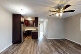 This single-floor residence offers a cohesive and functional layout designed for comfortable everyday living. Rich wood-look vinyl flooring runs throughout the space, providing a warm and consistent aesthetic from room to room. The open-concept living and dining area is bright and welcoming, featuring a ceiling fan with light fixture and a large window that invites natural light. A sliding glass door in the primary bedroom provides direct outdoor access, further enhancing the sense of openness.

The kitchen is a standout feature, outfitted with deep espresso-toned cabinetry, white quartz-style countertops, and a mosaic tile backsplash that adds a contemporary touch. Stainless steel appliances, including a refrigerator, dishwasher, and over-range microwave, complete the space efficiently.

The bedrooms are generously sized, each equipped with ceiling fans and mirrored sliding closet doors that maximize both storage and the sense of space. The bathroom is clean and well-appointed, featuring a dark wood vanity with a white countertop, a large mirror, and a tub-shower combination. Textured ceilings are present throughout, and neutral wall tones create a versatile backdrop suited to a variety of interior styles.