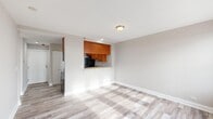 Located on the 8th floor at 10 N Sheridan Road in Waukegan, Illinois, this one-bedroom, one-bathroom residence offers a well-organized layout with modern finishes throughout. Light wood-style flooring runs continuously across the living areas, complementing the neutral, warm-toned walls that create a clean and cohesive aesthetic.

The kitchen is thoughtfully designed with rich warm-toned cabinetry extending to the ceiling for ample storage, light granite countertops, and a full suite of appliances including a refrigerator, electric range, and over-the-range microwave. A pass-through counter connects the kitchen to the open living area, enhancing the sense of space and facilitating easy interaction between rooms.

The living area is bright and open, benefiting from natural light and providing direct access to a private balcony through a sliding glass door. The balcony features decorative wrought iron railings and offers open outdoor views of the surrounding landscape.

The bedroom is a comfortable size, featuring a bank of windows that frame expansive outdoor views and flood the room with natural light. The bathroom is appointed with large-format travertine-style wall tiles surrounding a soaking jetted tub, adding a touch of elegance to the space. Overall, this residence presents a practical and attractive living environment with thoughtful details throughout.