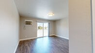 This single-floor, 2-bedroom unit in Livermore, CA offers a practical and well-organized layout across a compact but efficiently utilized footprint. The living area serves as the central gathering space, featuring rich hardwood-style flooring and a wall-mounted A/C unit. A sliding glass door floods the room with natural light and provides direct access to an outdoor area, offering views of the surrounding neighborhood.

The kitchen is thoughtfully designed with white shaker-style cabinetry, ample counter space, and a full suite of white appliances, including a refrigerator, range, dishwasher, and microwave. A window above the sink allows natural light to brighten the workspace, while hardwood-style flooring continues the cohesive aesthetic.

Both bedrooms are carpeted for comfort and feature neutral wall tones. The spacious primary bedroom includes a sliding-door closet with built-in rod storage and connects conveniently to the main living area. The second bedroom also features a sliding-door closet and a window with blinds for natural light and privacy. A dedicated entrance completes the layout. The overall ambiance is clean, neutral, and move-in ready.