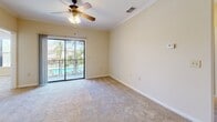 Located at 10011 Balaye Run Dr in Tampa, Florida, this single-story, 3-bedroom, 3-bathroom home offers a well-designed layout with a comfortable and functional living environment. The open-concept kitchen and living area forms the heart of the home, featuring light wood cabinetry, granite countertops, a tiled backsplash, black appliances, and a peninsula with a built-in sink — ideal for both cooking and casual dining. Tile flooring runs throughout the kitchen, while plush carpeting extends across the living room and all bedrooms, adding warmth underfoot. Crown molding and ceiling fans are consistent throughout, lending a polished, cohesive feel to the interior. The living and dining areas are bright and open, accented by an elegant chandelier. Each bedroom offers a ceiling fan, neutral tones, and natural light through blinded windows. The primary bedroom features sliding glass doors that open to a private balcony with serene pool and palm tree views. The bathrooms are well-appointed with granite vanity tops, tile flooring, and full tub-shower combinations. Large mirrors enhance the sense of space in the bathrooms. A dedicated laundry room and multiple closets add practical storage throughout. The home's layout flows naturally, connected by a central hallway with classic panel-style interior doors.