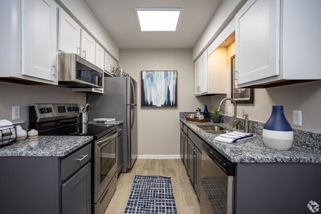 Kitchen with granite counters, stainless appliances, and modern cabinetry - Addison at Sutherland