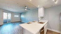 Located at 3535 El Portal Dr in Richmond, CA, this one-bedroom, one-bathroom unit offers a thoughtfully designed layout with modern finishes throughout. Wood-style plank flooring runs continuously across all living areas, lending a cohesive and contemporary feel to the space.

The open-concept kitchen flows directly into the living area and features white shaker cabinetry, white quartz countertops, a stainless steel undermount sink with a pull-down faucet, and a full suite of stainless steel appliances including a refrigerator, range, microwave, and dishwasher. A decorative tile backsplash adds a refined detail to the cooking space. A ceiling fan with integrated lighting in the living area enhances comfort, while a sliding glass door opens to a private balcony, bringing in natural light and outdoor views.

The bedroom is a well-proportioned retreat with a window for natural light, a dedicated closet, and access to the hallway. The bathroom includes a white vanity, a tiled shower-over-tub combination, and consistent neutral tones. A dedicated in-unit laundry area accommodates a full-size washer and dryer with overhead shelving for additional storage. The overall palette of soft blues, whites, and grays gives the unit a clean, modern ambiance.