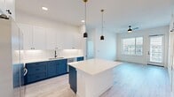 This well-appointed two-bedroom, two-bathroom unit at 4682 Beeler Court in Denver's Central Park neighborhood offers a thoughtfully designed single-level floor plan with contemporary finishes throughout. The open-concept kitchen and living area serves as the heart of the home, showcasing a striking two-tone kitchen with bold navy lower cabinets, crisp white upper cabinetry, a white subway tile backsplash, and a white quartz island illuminated by stylish matte black pendant lights. Light wood-style flooring extends throughout the main living areas, enhancing the bright, airy atmosphere.

The living room benefits from generous natural light through large windows and a sliding door that opens to an outdoor area, complemented by a ceiling fan overhead. Both bedrooms feature plush carpeting, ceiling fans, and walk-in closets outfitted with multi-level shelving and hanging rods. The primary bedroom includes direct access to its own bathroom. The bathrooms feature clean white tile surrounds with oil-rubbed bronze fixtures. A dedicated laundry area houses a stacked full-size washer and dryer, adding everyday convenience to this modern Denver residence.