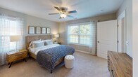 Located along Encore Circle in Maumee, Ohio, this single-floor residence offers a thoughtfully designed layout that blends comfort and functionality. The living area is a standout space, featuring soaring vaulted ceilings that amplify the sense of openness, light wood-style flooring, and a large sliding glass door that floods the room with natural light while providing views of the outdoors. The space flows seamlessly into a well-equipped kitchen outfitted with white cabinetry, granite-style countertops, stainless steel appliances including a refrigerator, range, and microwave, and a central island with a double sink — ideal for both everyday cooking and entertaining. The primary bedroom is a calm, carpeted retreat with dual windows, a ceiling fan, and direct access to an adjoining room or closet space. A second bedroom offers plush carpeting, a window with outdoor views, and a clean, versatile layout. Two bathrooms serve the home: one features a tub-shower combination with neutral finishes, while the other includes a vanity with ample counter space, overhead storage, and wood-style flooring. Throughout, the home maintains a consistent neutral palette, creating a warm and inviting atmosphere well-suited for comfortable everyday living.