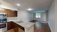 Located in Happy Valley, Oregon, this well-appointed 2-bedroom, 2-bathroom unit offers a practical and comfortable layout across a single floor. The open-concept kitchen and living area serves as the heart of the home, where rich wood-tone cabinetry, granite countertops, stainless steel appliances, and track lighting create a polished and functional cooking space. A breakfast bar adds casual dining convenience, while hardwood-style flooring flows throughout the kitchen and living areas, adding warmth and visual continuity.

The living room is bright and open, featuring a window that brings in natural light and a ceiling fan for added comfort. Both bedrooms are carpeted and offer a quiet, cozy atmosphere. The generously sized primary bedroom includes a ceiling fan, window with outdoor views, and direct access to its en-suite bathroom. The en-suite features a granite-topped vanity with dark wood cabinetry, a large mirror, and stylish fixtures. The second bathroom mirrors the same design aesthetic, complete with matching granite countertops, dark cabinetry, and wood-look flooring. A hallway connects the rooms efficiently, completing this thoughtfully designed residential unit.