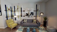 This well-appointed 1-bedroom, 1-bathroom unit is thoughtfully designed with a single-floor, open-concept layout that maximizes functional living space. The living area serves as the heart of the home, showcasing an artistic accent wall composed of vertical wood and painted panels in navy, white, and yellow-green tones, complemented by a bold canvas artwork. Wood-look flooring runs throughout, adding warmth and visual continuity across all rooms. A ceiling fan overhead enhances comfort in the living space.

The kitchen is a standout feature, offering dark espresso cabinetry, granite countertops, stainless steel appliances including a range, microwave, and refrigerator, and a double-basin sink. The galley-style layout provides ample counter and storage space, with pendant lighting adding a refined touch.

The bedroom is generously proportioned, featuring a ceiling fan, large windows dressed with sheer curtains that allow natural light to filter in, and direct access to a walk-in closet. The bathroom includes a full soaking tub and shower combination with clean white tile surround. Every room reflects a cohesive, contemporary aesthetic with vibrant accent colors woven throughout the décor.