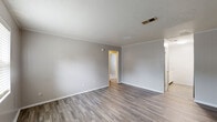 Located at 2534 Lumpkin Rd in Augusta, Georgia, this single-story, 3-bedroom, 1-bathroom home offers a straightforward and functional layout across its efficiently organized floor plan. The living area welcomes you with durable laminate hardwood-style flooring, vertical shiplap-style wall paneling, and a textured ceiling with a central HVAC vent — details that carry consistently throughout the main living spaces. A window allows natural light to brighten the room, creating an inviting atmosphere. The spacious primary bedroom continues the laminate flooring theme, while the two additional bedrooms feature soft carpeting underfoot and individual windows that bring in natural light. All bedrooms showcase the same neutral-toned vertical wall paneling, giving the home a cohesive aesthetic. The galley-style kitchen is efficiently designed, featuring white cabinetry, granite-look countertops, a stainless steel refrigerator, an electric range, and light laminate flooring — making excellent use of the available space. The bathroom is clean and functional, equipped with a full tub-and-shower combo featuring chrome fixtures. A hallway and dedicated closet round out the interior, adding to the home's practical storage and circulation. Overall, the space presents a clean, updated, and move-in ready environment.