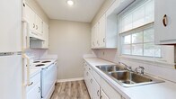 Located at 607 Woodbury Hwy in Manchester, Tennessee, this single-floor 1-bedroom, 1-bathroom home offers a clean, updated interior with a cohesive neutral color palette throughout. Light wood-tone luxury vinyl plank flooring runs continuously across the entire space, lending a modern and cohesive aesthetic.

The living room is a generously sized, open area featuring a vertical shiplap-style accent wall, built-in shelving, and a central ceiling light fixture. Natural light enters through large windows, creating a bright and welcoming atmosphere.

The kitchen is laid out in a practical galley configuration, equipped with white cabinetry, white countertops, a white electric range, and a double stainless steel sink positioned beneath a window. Ample upper and lower cabinet storage makes the space highly functional.

The bedroom is a comfortable, well-lit room with a window overlooking the exterior and a closet with a built-in rod for storage. The neutral walls and light flooring carry through from the rest of the home.

The bathroom includes a full soaking tub, a vanity with under-sink storage, and a window that allows natural light to brighten the space. Light tile-style flooring complements the clean white fixtures throughout.