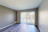 Located at 5800 Maplebrook Ln in Flint, Michigan, this efficiently designed one-bedroom, one-bathroom residence offers a thoughtful layout across a single floor. Contemporary wood-look luxury vinyl flooring flows throughout the entire unit, complementing the neutral, warm-toned walls that create a clean and cohesive aesthetic.

The living room is a bright, welcoming space anchored by a large sliding glass door fitted with vertical blinds, allowing abundant natural light and providing views of the surrounding greenery. The galley-style kitchen is a standout feature, boasting white shaker cabinetry with brushed nickel hardware, crisp white quartz countertops, a subway tile backsplash in a soft blue-gray tone, a stainless steel undermount sink with a matte black faucet, and stainless steel appliances including a refrigerator and over-the-range microwave.

The bedroom is a comfortable, well-proportioned room with a large window that frames outdoor tree views and a sliding closet door providing convenient storage. The bathroom is finished with a white vanity, white countertop, and brushed nickel fixtures and towel hardware, maintaining the unit's consistent, modern style. This residence offers a move-in ready experience with updated finishes throughout.