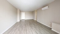 This two-bedroom, two-bathroom residence in Silver Spring, Maryland offers a well-organized single-floor layout with a thoughtful mix of living spaces. The open living and dining area is a standout feature, finished with light-toned wood-style flooring that extends throughout the main areas, creating a clean and cohesive aesthetic. A wall-mounted mini-split A/C unit provides efficient climate control, while large sliding glass doors lead directly to a private patio, filling the space with natural light and offering outdoor views. The kitchen is equipped with a gas range and ample cabinetry, positioned near the entryway for convenient access. Both bedrooms are carpeted for comfort — the generously sized primary bedroom includes a wall-mounted A/C unit and a large window with exterior views, while the second bedroom also features its own mini-split system. Four closets throughout the unit ensure ample storage. The bathrooms are functional and well-appointed, featuring wood-toned vanity cabinetry, light countertops, and wood-style flooring. Neutral warm-beige walls throughout the entire residence contribute to a calm, versatile ambiance suited to a variety of living styles.