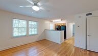 This single-floor residence offers a clean, functional layout with a warm and bright ambiance throughout. The open-concept living and dining area is highlighted by gleaming hardwood floors, crisp white walls, and a ceiling fan that adds both comfort and character. Multiple windows allow natural light to pour in, offering pleasant outdoor views and a welcoming atmosphere.

The kitchen is positioned behind a peninsula counter with dark countertops, providing a natural divide between the living space and the cooking area. Warm-toned wooden cabinetry pairs with black appliances, including a full-size refrigerator, microwave, and dishwasher. Tile flooring in the kitchen offers easy maintenance, while a window above the sink brings in additional natural light.

The bedrooms are carpeted for comfort and feature ceiling fans, neutral-toned walls, and windows fitted with blinds. Each room offers a quiet, versatile space suitable for a variety of uses. A dedicated entry area with hardwood flooring and a solid door with a keypad lock adds a practical and secure entry point.

The bathroom is well-appointed with full white subway tile surrounding a tub-shower combination, a window for natural ventilation, and light tile flooring — giving it a clean and timeless look throughout.
