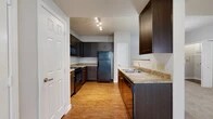 Located at 408 Nottinghill Gate St in Arlington, TX, this single-floor residence offers a practical and comfortable layout with two bedrooms, two bathrooms, and three closets. The kitchen is a standout feature, showcasing rich dark espresso cabinetry, granite-style countertops, black appliances including a refrigerator, range, built-in microwave, and dishwasher, as well as a double stainless steel sink. Warm wood-look flooring runs throughout the kitchen, complemented by track lighting overhead and pendant lighting near the sink area. The living room is bright and welcoming, with plush carpeting, a ceiling fan with integrated light, and multiple windows with blinds that allow natural light to fill the space. A glass-paneled door provides direct outdoor access. Both bedrooms are carpeted and finished in neutral tones, offering a calm atmosphere. The primary bedroom includes dedicated closet space. The bathrooms are well-appointed, with one featuring a tiled tub-and-shower combo with chrome fixtures and wood-toned cabinetry above. Throughout the residence, clean white trim, neutral wall tones, and consistent finishes create a cohesive and move-in-ready environment.