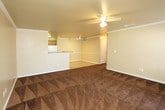 Located at 1510 E Cornell St in Lubbock, Texas, this single-floor residence offers a functional and comfortable layout designed for everyday living. The open-concept living area features rich, patterned carpet and crown molding, flowing seamlessly into the kitchen via a raised breakfast bar with granite-style countertops. The kitchen is well-equipped with warm oak cabinetry, dark stone-look countertops, a white electric range, built-in microwave, dishwasher, and a utility sink, all set atop light ceramic tile flooring. Two generously sized bedrooms are finished with plush dark carpet and each includes a ceiling fan with light fixture and a window fitted with blinds, allowing natural light to filter in. The two full bathrooms mirror each other in design, each featuring a single-sink vanity with wood cabinetry, white countertops, a large wall mirror with overhead lighting, a tub-shower combination, and tile flooring. Neutral wall tones throughout the home create a clean, cohesive atmosphere. Ceiling fans are present in the main living area as well, enhancing airflow and comfort. The layout, as seen in the dollhouse view, is efficiently organized with clear separation between living, kitchen, and private bedroom spaces.