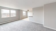 This 760 square foot apartment in Williamsville, New York offers a well-designed living space with two bedrooms and one bathroom. The single-floor layout maximizes functionality, with the primary bedroom boasting a generous 170 square feet. The kitchen is a standout feature, showcasing rich cherry-wood cabinetry, granite countertops, and stainless steel appliances, including a built-in microwave. The open concept living and dining area is bathed in natural light from large windows, creating an airy ambiance. Neutral wall colors and plush carpeting in the bedrooms and living spaces contribute to a modern, clean aesthetic. The bathroom features a white suite with a shower/tub combination. Ample closet space provides storage solutions throughout the apartment. Baseboard heating ensures comfort year-round. The property's location at 6 East Spring Street places residents in the heart of Williamsville, offering a blend of suburban tranquility and urban convenience.
