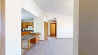 Located at 2404 Heathrow Dr in Champaign, Illinois, this single-story home offers a well-organized open-concept layout that connects the main living areas seamlessly. The living room is a standout space, featuring vaulted ceilings, a ceiling fan, a corner fireplace, and a window that brings in natural light, all set over plush carpeting that extends throughout the living and bedroom areas.

The kitchen is generously sized, equipped with warm oak cabinetry spanning the full perimeter, dark laminate countertops, a full suite of appliances including a range, refrigerator, and microwave, and tile flooring. A peninsula with a granite-toned surface and decorative legs serves as a natural divider between the kitchen and the open living and dining space, providing additional prep and seating area.

The bedrooms are carpeted and well-proportioned, each featuring ceiling fans and ample closet space, including at least one room with an open built-in closet system. The bathrooms include oak vanity cabinetry, a mirror medicine cabinet, and a tub-shower combination with tile flooring. A dedicated laundry area with washer and dryer hookups adds everyday convenience to this functional and cohesive single-floor home.
