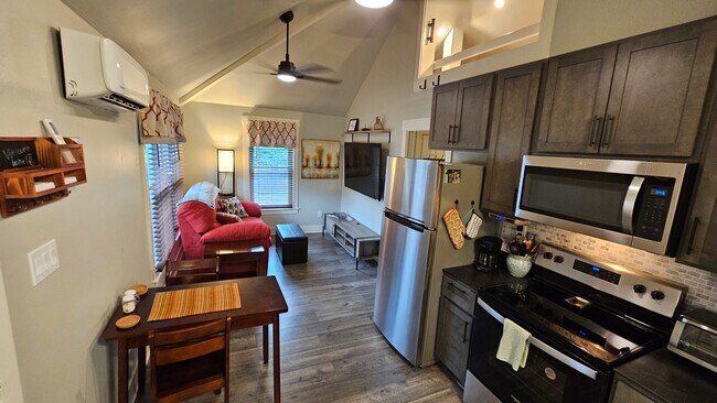 Sala de estar con acogedor comedor, televisor inteligente grande y mucha luz natural. - 502 Arbutus Ave SE