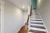 Located at 843 Portside Pl in Chattanooga, Tennessee, this three-story home offers four bedrooms and six bathrooms thoughtfully distributed across its floors. The ground level includes an attached garage with an automatic opener, as well as utility spaces for added convenience.

The main living floor serves as the heart of the home, featuring an open-concept layout that combines the living room, dining area, and kitchen in a single flowing space. The kitchen is equipped with stainless steel appliances, gray shaker-style cabinetry, light countertops, and rich hardwood flooring that extends throughout the main level. A dedicated pantry adds practical storage. A staircase with wood treads and a modern metal-and-wood railing connects the floors with architectural elegance.

The upper floor is home to the bedrooms, including a spacious primary suite featuring vaulted ceilings, dual windows that invite natural light, and plush carpeting. The primary suite connects to its own bathroom and closet. Additional bedrooms are well-sized and share access to well-appointed bathrooms with tile flooring. The upper hallways are lined with multiple closets, including walk-in options with built-in shelving. A dedicated laundry room adds everyday convenience. Throughout, neutral tones and clean finishes create a bright, cohesive atmosphere.