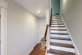 Located at 843 Portside Pl in Chattanooga, Tennessee, this three-story home offers four bedrooms and six bathrooms thoughtfully distributed across its floors. The ground level includes an attached garage with an automatic opener, as well as utility spaces for added convenience.

The main living floor serves as the heart of the home, featuring an open-concept layout that combines the living room, dining area, and kitchen in a single flowing space. The kitchen is equipped with stainless steel appliances, gray shaker-style cabinetry, light countertops, and rich hardwood flooring that extends throughout the main level. A dedicated pantry adds practical storage. A staircase with wood treads and a modern metal-and-wood railing connects the floors with architectural elegance.

The upper floor is home to the bedrooms, including a spacious primary suite featuring vaulted ceilings, dual windows that invite natural light, and plush carpeting. The primary suite connects to its own bathroom and closet. Additional bedrooms are well-sized and share access to well-appointed bathrooms with tile flooring. The upper hallways are lined with multiple closets, including walk-in options with built-in shelving. A dedicated laundry room adds everyday convenience. Throughout, neutral tones and clean finishes create a bright, cohesive atmosphere.
