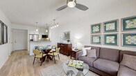 Located in the desirable Carmel Valley neighborhood of San Diego, this 2-bedroom, 2-bathroom residence offers a thoughtfully designed single-floor layout that maximizes both comfort and functionality. The open-concept living and dining area is bright and welcoming, with light wood-style flooring, large windows that invite natural light, and a ceiling fan overhead. The space flows seamlessly into a sleek, modern kitchen outfitted with white shaker cabinetry, stainless steel appliances including a gas range and French door refrigerator, a tiled backsplash, and a peninsula with quartz-style countertops and bar seating — ideal for casual dining or entertaining. Each bedroom features plush carpeting, generous closet space, and windows with views of surrounding greenery. The primary bedroom is a comfortable retreat with ample room for furnishings. Both bathrooms are finished with large-format light tile flooring, tub-shower combinations accented with decorative mosaic tile inlays, white vanities, and clean, contemporary fixtures. A dedicated laundry area and multiple closets throughout add to the home's practicality. The overall ambiance is fresh, modern, and move-in ready, reflecting a clean coastal aesthetic well-suited to the San Diego lifestyle.