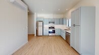 This 360-square-foot studio apartment, located at 201 River St in Santa Cruz, CA, offers a modern and efficient living space. The single-floor layout maximizes functionality within its compact footprint. The interior features a contemporary design with light wood-tone flooring throughout, creating a warm and inviting atmosphere.

The kitchen is a standout feature, boasting light blue cabinetry that adds a touch of coastal charm. Stainless steel appliances, including a full-size refrigerator, range, and microwave, provide all the necessities for culinary pursuits. The L-shaped kitchen layout offers ample counter space and storage.

Natural light floods the space through a large sliding glass door and additional windows, enhancing the sense of openness. The main living area is versatile, allowing for multiple furniture arrangements to suit various needs. Recessed lighting in the ceiling provides additional illumination options.

The apartment is part of a larger residential complex, featuring a white exterior with balconies and surrounded by mature trees. This setting offers a blend of urban convenience and natural beauty, typical of Santa Cruz living. The compact yet well-designed space is ideal for those seeking an efficient, low-maintenance lifestyle in a prime location.
