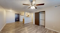 This efficiently designed single-floor unit offers a practical and functional layout encompassing a combined kitchen and living area along with one full bathroom. The open-concept living space is finished with durable wood-look plank flooring that runs throughout, creating a cohesive and easy-to-maintain interior. A ceiling fan with integrated lighting anchors the living area, providing both comfort and illumination. The space benefits from a window that allows natural light to fill the room, complemented by neutral-toned walls that enhance the sense of openness.

The kitchen is thoughtfully arranged with warm oak-trimmed cabinetry featuring white cabinet faces, offering ample storage above and below. White appliances—including a refrigerator, electric range, microwave, and dishwasher—are neatly integrated alongside a stainless steel sink. A pass-through window connects the kitchen to the living area, fostering an open, airy feel. A closet with hanging storage provides organizational convenience.

The bathroom features a full-size tub and shower combination, a single vanity with storage, and consistent wood-look flooring. Textured ceilings are present throughout, adding a classic finishing detail. Overall, the unit presents a clean, functional living environment with a well-considered use of its compact footprint.