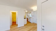 Located on Crenshaw Boulevard in Los Angeles, this thoughtfully updated 1-bedroom, 1-bathroom unit offers a clean, modern aesthetic throughout its efficiently designed single-floor layout. Light wood vinyl flooring flows seamlessly through every room, creating a warm and cohesive feel.

The combined kitchen and living area serves as the heart of the unit. The galley-style kitchen is a standout feature, outfitted with crisp white shaker cabinets, black hardware accents, quartz countertops, a stainless steel undermount sink, and a full suite of stainless steel appliances including a gas range, over-the-range microwave, and refrigerator. A window with blinds allows natural light to brighten the workspace. The adjacent living area offers an open, airy feel with a ceiling fan and access to the hallway.

The bedroom is a comfortable, well-appointed retreat featuring a ceiling fan with light fixture, a large window with views of the surrounding neighborhood, and a full-width mirrored sliding closet paired with additional upper cabinetry for generous storage. The clean white walls and light flooring keep the room feeling bright and open.

The bathroom is neatly finished with a shower/tub combo, a white vanity, and matching light wood flooring, maintaining the consistent design language found throughout the unit. A connecting hallway completes the practical, well-organized floor plan.