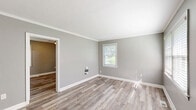 Located at 250 Crumps Park Ave in Macon, Georgia, this single-story, 2-bedroom, 1-bathroom home offers a practical and comfortable layout. Throughout the home, durable hardwood-style flooring in warm neutral tones provides a cohesive and clean aesthetic, complemented by cool gray walls and crisp white trim.

The spacious primary bedroom is a standout feature of the home, offering generous room to accommodate a full furniture arrangement. It benefits from multiple windows that invite natural light and includes a ceiling fan for year-round comfort. The second bedroom is similarly appointed, with its own ceiling fan, hardwood-style floors, and a window overlooking the exterior.

The living area connects fluidly to the rest of the home and features crown molding, adding a refined touch to the otherwise straightforward design. The kitchen is functional and well-organized, featuring white cabinetry, granite-look countertops, a stainless steel sink, and light-toned flooring. A rear door in the kitchen provides convenient exterior access, while a window fills the space with natural light.

The bathroom is clean and efficient, featuring white tile surrounds, a tub-shower combination, a white vanity with sink, and a decorative mosaic tile accent that adds a touch of visual interest. This home presents a well-maintained, move-in ready layout suited for comfortable everyday living.