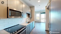 Located at 1005 West Main Street in Durham, NC, this thoughtfully designed one-bedroom, one-bathroom unit offers a efficient and modern single-floor layout. Light wood-style flooring flows throughout, complementing a neutral color palette that creates a clean, cohesive aesthetic.

The galley-style kitchen is a standout feature, showcasing two-toned cabinetry with grey upper cabinets and teal-accented lower units, white quartz countertops, and a classic white subway tile backsplash. A full suite of stainless steel appliances — including a French door refrigerator, range, built-in microwave, and dishwasher — provides everything needed for daily living. The kitchen opens toward the living area, which benefits from natural light through a large window and access to a private balcony.

The bedroom is a comfortable, well-proportioned retreat with a ceiling fan and a dedicated closet with double doors. The bathroom features a wall-mounted vanity with a white basin, wood-look tile flooring, and a glass-enclosed walk-in shower finished with large white subway tiles.

Completing the layout are a welcoming entrance, a utility room, and additional closet space — all contributing to a functional and stylish living environment in the heart of Durham.