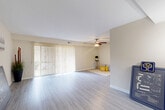 This 2-bedroom, 1-bathroom home in Gaithersburg, MD offers a well-designed single-floor layout with a thoughtful blend of comfort and functionality. The open-concept living, dining, and kitchen area forms the heart of the home, bathed in natural light streaming through large sliding glass doors fitted with vertical blinds that lead to an outdoor view. Light-toned hardwood-style flooring runs throughout the main living space, complemented by a ceiling fan overhead that adds both style and practicality.

The kitchen is well-appointed with rich dark wood cabinetry, granite-style countertops, black appliances including a gas range, dishwasher, and refrigerator, and tile flooring with a skylight-style overhead fixture that keeps the space bright and inviting.

The spacious primary bedroom features plush carpeting and direct access to the full bathroom, which boasts a wide vanity with a white countertop, dark wood cabinetry, and a large mirror. The second bedroom is equally comfortable, with carpeted floors and a window that brings in natural light.

With five closets throughout, storage is abundant. The neutral, warm color palette across all rooms creates a cohesive and welcoming ambiance throughout this well-maintained Gaithersburg home.