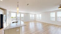 Located in Richmond Heights, Missouri, this well-appointed single-floor residence offers three bedrooms, three bathrooms, and a thoughtfully designed open-concept layout. The expansive living and kitchen area is the heart of the home, characterized by light hardwood flooring, abundant natural light from multiple large windows, and a clean, contemporary aesthetic with crisp white walls. The chef's kitchen is a standout feature, boasting a generous granite-topped island with an undermount sink, light wood cabinetry, white tile backsplash, a stainless steel refrigerator, built-in double wall ovens, a gas cooktop, and a stainless range hood — all illuminated by a row of modern pendant lights. The spacious primary bedroom benefits from a bank of windows offering outdoor views and is complemented by its own closet. Secondary bedrooms include plush carpeting, ceiling fans, and ample natural light. The bathrooms are finished with granite vanities, light wood cabinetry, and built-in shelving. A dedicated laundry room includes a full-size washer and dryer. Three closets provide excellent storage throughout. This residence combines modern finishes with a bright, open ambiance for comfortable everyday living.