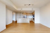 Located on the 26th floor in the heart of Seattle, this 2-bedroom, 2-bathroom residence offers a thoughtfully designed open-concept layout with generous living space. Warm bamboo-style hardwood flooring flows throughout, complementing the clean, modern aesthetic defined by crisp white walls and tray ceilings with recessed and track lighting.

The combined living, dining, and kitchen area forms the heart of the home. The chef's kitchen features light wood cabinetry, a marble-look tile backsplash, stainless steel appliances including a French door refrigerator and double wall ovens, and a large center island with a quartz countertop — ideal for both cooking and entertaining. Floor-to-ceiling windows in the living area flood the space with natural light and frame dramatic downtown Seattle skyline views, with direct access to a private balcony.

The spacious primary bedroom offers its own city views through expansive windows, while both bedrooms benefit from abundant closet space, including custom-built organizers with shelving and drawers. A versatile den provides additional flexible living space. The bathrooms are finished with travertine tile, including a soaking tub with tiled surround. With five closets total, storage is plentiful throughout this well-appointed urban residence.