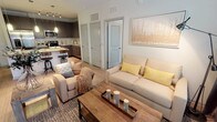 This 2-bedroom, 2-bathroom single-story residence offers a thoughtfully designed open-concept layout that connects the living, dining, and kitchen areas into a cohesive, functional space. Light wood-style flooring runs throughout the main living areas, complementing the neutral color palette and creating a warm, inviting ambiance.

The kitchen is a standout feature, equipped with stainless steel appliances including a French door refrigerator, electric range, and built-in microwave. Dark gray cabinetry pairs with granite countertops and a classic white subway tile backsplash. A peninsula island with pendant lighting provides bar seating, making it ideal for casual dining or entertaining.

The living room benefits from multiple windows that allow natural light to fill the space, and a ceiling fan adds comfort. Both bedrooms feature ceiling fans, plush carpeting, generous walk-in closet space with wire shelving systems, and large windows with natural light.

The bathrooms are finished with dark cabinetry, granite countertops, and a combination tub and shower with tile surround. The primary bathroom includes a double vanity with ample counter space, directly accessible from the primary bedroom.
