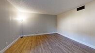 Located at 4729 Manzanita Ave in Carmichael, California, this one-bedroom, two-bathroom residence offers a practical and well-appointed single-floor layout. Wood-look luxury vinyl flooring runs consistently throughout the unit, complementing the neutral gray tones of the walls and white baseboards for a clean, cohesive aesthetic. The textured ceilings add a classic touch seen across all rooms.

The living area is an open, light-filled space anchored by a sliding glass door that leads to a private enclosed patio, allowing natural light to flow in and providing convenient outdoor access. The kitchen is efficiently designed with crisp white cabinetry, black hardware, dark countertops, a stainless steel sink, and a black electric range with overhead ventilation — maximizing both storage and functionality.

The bedroom is a comfortably sized retreat featuring a window with blinds that frames a view of surrounding greenery, and a closet fitted with sleek black-framed mirrored sliding doors that add depth and style.

Both bathrooms are thoughtfully updated. One features a full tub-shower combination with black fixtures and a white vanity topped with a dark countertop and large mirror. The second bathroom mirrors this aesthetic with a wide vanity, ample cabinet storage, and modern lighting, delivering a polished, cohesive finish throughout.