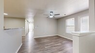 Located at 1729 Lakewood Terr in Belton, MO, this single-story, 3-bedroom, 2-bathroom home offers a well-designed layout with modern finishes throughout. The open living room greets you with wood-look vinyl plank flooring, a ceiling fan, and a textured ceiling, with natural light streaming in through blinded windows and access to an exterior door. The kitchen is a standout, featuring white shaker cabinetry, granite-look countertops, stainless steel appliances including a range, microwave, dishwasher, and refrigerator, as well as a peninsula that provides additional prep and seating space. The flooring transitions to plush carpet in all three bedrooms, each equipped with ceiling fans and windows that bring in ample natural light. The primary bedroom is generously sized and connects to a bathroom with white cabinetry, granite countertops, and a dedicated walk-in closet with built-in shelving. A second full bathroom serves the remaining bedrooms. A dedicated laundry area accommodates a full-size washer and dryer with overhead shelving for added storage. Neutral gray tones, white trim, and consistent finishes create a cohesive and move-in-ready aesthetic throughout the entire home.