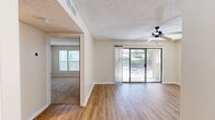 This well-appointed 2-bedroom, 2-bathroom single-floor home in El Paso, TX offers a practical and comfortable layout designed for everyday living. The living room is a bright, open space anchored by wood-look hardwood flooring, a ceiling fan, and a large sliding glass door that fills the room with natural light and provides direct access to an outdoor patio with views of the surrounding greenery. The adjacent dining area features a pendant light fixture, continuing the open feel of the main living space.

The galley-style kitchen is efficiently arranged with warm wood cabinetry, granite-look countertops, black appliances, and a skylight-style ceiling panel that brightens the workspace. A pantry with built-in shelving adds convenient storage just off the kitchen.

Both bedrooms offer plush carpeting and natural light through windows with blinds. The spacious primary bedroom includes access to a walk-in closet outfitted with dual hanging rods and shelving on both sides. The home includes four closets in total, providing ample storage throughout.

The two bathrooms are clean and functional. One features a tub-shower combo with white tile surround, while the other includes a wood-toned vanity with granite countertop and wood-look tile flooring. Textured ceilings are present throughout, adding a classic finishing touch to this move-in-ready home.