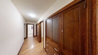 Located in the desirable Queen Anne neighborhood of Seattle, this single-floor residence at 900 Queen Anne Ave N, Unit 301, offers a well-organized layout with classic architectural details throughout. Warm hardwood flooring extends across the living and bedroom areas, complemented by rich dark wood trim that frames the windows and doorways, lending a traditional and cohesive character to the space.

The bedrooms are generously proportioned, each featuring hardwood floors and wood-trimmed windows that bring in natural light and offer views of surrounding greenery and the neighborhood streetscape. One bedroom includes a closet with built-in shelving, while another benefits from multiple windows on adjacent walls, creating a bright and airy atmosphere.

The hallway is a standout feature, lined with substantial built-in dark wood cabinetry complete with paneled doors and crystal-style hardware — providing ample storage while adding a refined, craftsman-inspired aesthetic. The hallway leads to a bathroom visible at the far end.

The kitchen is efficiently designed with warm wood cabinetry on both sides, light-toned countertops, and classic hexagonal tile flooring. It is equipped with a range, overhead microwave, refrigerator, and a sink, along with glass-front upper cabinets that add a touch of openness. The overall ambiance of the unit is warm, functional, and rooted in timeless residential design.