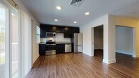 Located at 704 Pleasant Valley Rd N in Groton, Connecticut, this single-floor unit offers a thoughtfully designed layout with contemporary finishes throughout. The kitchen serves as a focal point of the space, outfitted with dark espresso cabinetry, granite-style countertops, and a full suite of stainless steel appliances including a range, over-the-range microwave, dishwasher, and a bottom-freezer refrigerator. Warm wood-look plank flooring runs continuously through the kitchen and living areas, creating a cohesive and inviting atmosphere. Recessed lighting in the kitchen provides bright, even illumination, complementing the natural light that enters through the windows.

A standout architectural detail is the white sliding barn door with matte black hardware, which connects the living area to the kitchen, adding a modern farmhouse aesthetic to the space. The living and bedroom areas are open and well-proportioned, with neutral walls and consistent wood-look flooring. The bathroom features classic black-and-white hexagonal tile flooring, white subway tile surrounding the tub-shower combo, and brushed nickel fixtures, offering a clean and timeless design. Overall, the unit presents a polished, move-in-ready interior with cohesive modern styling.