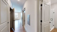 Located at 500 Congaree Rd in Greenville, South Carolina, this one-bedroom, one-bathroom unit offers a thoughtfully designed single-level layout that maximizes every square foot. The open-concept kitchen and living area serves as the heart of the home, featuring warm hardwood-style flooring, recessed lighting, and a bright, airy atmosphere. The kitchen is well-appointed with white shaker cabinetry, dark hardware accents, charcoal quartz countertops, a classic white subway tile backsplash, and a full suite of stainless steel appliances including a refrigerator, range, microwave, and dishwasher. Natural light fills the space through windows overlooking the surrounding community, with access to an outdoor balcony area. A sliding barn door adds a modern touch to the hallway, which also features an in-unit electrical panel for convenience. The bedroom offers a cozy, carpeted retreat with neutral tones and ample wall space. The bathroom is well-finished with white cabinetry, generous built-in storage, dark-framed mirror, quartz countertop, an undermount sink with a matte black faucet, and wood-look tile flooring. Double doors lead to a dedicated closet, completing this clean and contemporary living space.