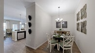 Located at 915 Robert Rose Dr in Murfreesboro, TN, this single-story, one-bedroom, two-bathroom residence offers a thoughtfully designed layout that maximizes every square foot. The galley-style kitchen is outfitted with dark cabinetry, granite countertops, stainless steel appliances, and pendant lighting, creating a sleek, functional workspace. Crown molding throughout adds a refined architectural touch. Adjacent to the kitchen, the dedicated dining area features hardwood-style flooring, a stylish chandelier, and crisp crown molding, offering an inviting space for meals. The living room is filled with natural light streaming through multiple windows and a glass door, complemented by hardwood-style floors and clean neutral walls. The spacious primary bedroom is carpeted for comfort, includes a ceiling fan, a large window with natural light, and direct access to a walk-in closet. Both bathrooms are finished with tile flooring and clean, neutral tones — one featuring a shower/tub combination. The consistent use of neutral gray walls, crown molding, and wood-look flooring throughout creates a cohesive, modern ambiance well-suited for comfortable everyday living.