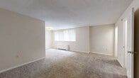 Located at 8508 16th St in Silver Spring, MD, this two-bedroom, one-bathroom residence offers a well-organized single-floor layout designed for comfortable everyday living. The living area is bright and open, featuring neutral beige carpet, a textured ceiling, and a large window fitted with vertical blinds that allows natural light to fill the room. A baseboard heating unit runs along the window wall, ensuring year-round comfort.

The primary bedroom is generously proportioned, offering ample room for furnishings, and includes two dedicated closets with paneled doors. A ceiling fan with a light fixture provides both circulation and illumination. The second bedroom is similarly carpeted and features its own ceiling fan and a window with views of surrounding greenery.

The kitchen stands out with warm wood cabinetry, dark granite countertops, wood-look vinyl flooring, and black appliances including a refrigerator and dishwasher. The full bathroom includes a soaking tub with a tiled surround, a wall-mounted mirror cabinet, and tile flooring. Two closets throughout the unit provide practical storage solutions. The overall aesthetic is clean, neutral, and functional, making this a well-appointed residence in a convenient Silver Spring location.