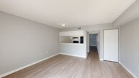 This two-story townhome in Kissimmee, Florida offers a practical and comfortable layout spread across two well-proportioned floors. The exterior features warm tan siding set against lush green communal grounds, providing an inviting Florida setting with mature trees and open lawn areas.

On the main floor, the living room is bright and airy, featuring light wood-style luxury vinyl flooring, neutral gray walls, a textured ceiling, and a sliding glass door that floods the space with natural light and opens to a view of the greenery outside. The kitchen is efficiently laid out with white shaker-style cabinetry, granite-look countertops, a double-basin sink, and a black dishwasher — all finished with coordinating light flooring.

Upstairs, the two bedrooms are carpeted for comfort, finished with the same neutral gray palette, and feature textured ceilings with window blinds allowing natural light. The generously sized primary bedroom includes ample closet space. A ceiling fan adds to the comfort of an additional room on this floor.

Three bathrooms serve the home, including one with a full tub-shower combination featuring white subway tile surround, wood-look flooring, and granite-style countertops with a white vanity. The clean, neutral finishes throughout give the home a move-in-ready feel.