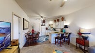 This well-designed one-bedroom, one-bathroom residence makes excellent use of its compact footprint across a single floor. The open-concept layout seamlessly connects the living room, dining area, and kitchen, creating a cohesive and functional living space.

The living room features vaulted ceilings, a ceiling fan, and a large window that invites natural light, lending a sense of openness to the space. Hard flooring transitions into carpet, defining the different zones within the open plan.

The kitchen is equipped with white cabinetry offering ample storage, a double sink, full-size appliances including a refrigerator, electric range, dishwasher, and built-in microwave. A peninsula with a breakfast bar provides both additional counter space and casual seating for two. The adjacent dining area comfortably accommodates a full dining table and chairs.

A hallway lined with built-in closet storage on both sides leads to the bedroom, providing generous wardrobe space. The bedroom is a comfortable size, featuring its own ceiling fan, a large window with outdoor views, and plush carpeting. The layout is completed by a full bathroom.

Overall, the residence offers a practical and inviting design with efficient use of space throughout.