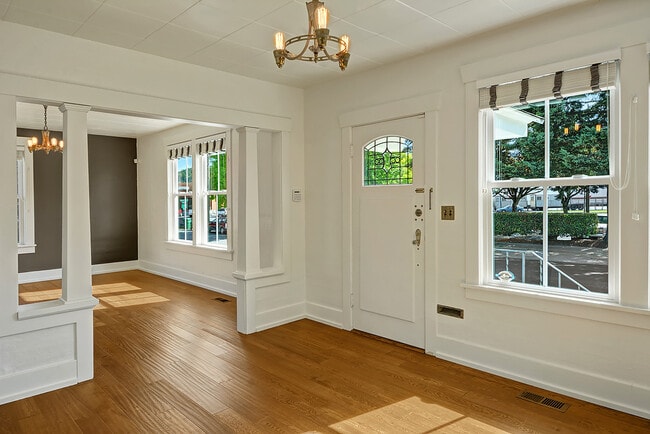 Large living/dining room with exposed hardwood floors. - 5403 Maynard Ave S