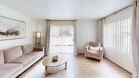 Located in Canyon Country, CA, this single-floor, 2-bedroom, 2-bathroom home offers a well-organized layout designed for comfortable everyday living. The bright living room serves as the heart of the space, featuring warm wood-style flooring, clean white walls, and large sliding glass doors dressed with vertical blinds and draped curtains that invite ample natural light and provide views of greenery outside. The open feel of the living area transitions smoothly into the hallway connecting the rest of the home. The kitchen is efficiently designed with white cabinetry extending to the ceiling for generous storage, light quartz-style countertops, a stainless steel gas range, a full-size refrigerator, and a double sink beneath a window. Both bedrooms are carpeted and serene, with the primary bedroom offering a comfortable footprint, a dedicated closet, and an adjoining bathroom. The second bedroom is similarly well-appointed with closet access. Three closets throughout the home provide ample storage. Both bathrooms are clean and functional, each featuring a tub-shower combo with white tile surround and a vanity with a wide mirror. The overall aesthetic is neutral and bright, creating a calm, move-in-ready atmosphere throughout.