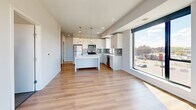 Located at 2615 E 29th Street in Minneapolis, MN, this modern 2-bedroom, 2-bathroom unit offers a well-designed layout with clean, contemporary finishes throughout. The open-concept kitchen and living area serves as the heart of the space, featuring light wood-style flooring, white cabinetry, a center island with pendant lighting, stainless steel appliances, and a subway tile backsplash. Large floor-to-ceiling windows flood the area with natural light and provide elevated views of the surrounding Minneapolis neighborhood. The two bedrooms are carpeted for comfort and each offer generous closet storage. The primary bedroom benefits from wide windows framing city views, while both rooms maintain a bright, neutral palette. The two full bathrooms each include a tub-shower combination with brushed nickel fixtures and light wood-style flooring, maintaining the unit's consistent modern aesthetic. A dedicated laundry area adds everyday convenience. A central hallway connects the rooms efficiently, and multiple closets provide ample storage throughout. The overall ambiance is clean, contemporary, and functional, making this a well-appointed urban residence in Minneapolis.