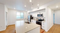 Located in Ridgefield, WA, this single-floor, three-bedroom, two-bathroom home offers a clean, modern design with a cohesive aesthetic throughout. The open-concept kitchen and living area serves as the heart of the home, featuring a large center island with an integrated sink, white cabinetry, stainless steel appliances, and recessed lighting. Natural light fills the space through multiple windows, complemented by warm hardwood-style flooring that runs through the main living areas and hallways.

The three bedrooms provide comfortable accommodations, with plush carpeting and windows fitted with blinds for privacy. The primary bedroom includes its own dedicated space with ample room, while additional bedrooms offer built-in closets for convenient storage. A dedicated walk-in closet with wire shelving provides extra organizational space.

Both bathrooms are finished in a bright, clean style, each featuring a full bathtub and shower combination, wood-style flooring, and white vanities with neutral countertops. The hallways connect the rooms efficiently, with one offering a glimpse into the well-appointed bathroom vanity area.

A wall-mounted mini-split unit ensures year-round climate control. The home also includes a dedicated laundry room and an exterior door off the living area providing outdoor access, rounding out this well-appointed, move-in-ready residence.