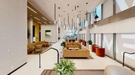 The Millway's amenity floor is a thoughtfully designed, large-scale communal space that blends contemporary architecture with refined, hospitality-inspired interiors. The centrepiece is a soaring double-height lobby and lounge area, punctuated by dramatic cascading linear pendant lights that draw the eye upward and set an elevated tone throughout. Floor-to-ceiling windows wrap the perimeter, flooding the space with natural light and offering sweeping panoramic views of the surrounding cityscape and beyond.

The open-plan lounge is furnished with a curated mix of warm-toned sofas, rounded accent chairs in amber and terracotta, and sculptural seating pieces, all arranged to encourage both social interaction and relaxed individual use. Lush potted greenery is integrated throughout, adding a natural softness to the clean, neutral palette of white polished floors and textured wall panels.

Multiple distinct zones are thoughtfully distributed across the floor, including dining and co-working areas with wooden tables and modern chairs, a formal boardroom with floor-to-ceiling views, a quiet retreat room with acoustic panelling and a lounge chair, and a casual café-style seating section. A tiered platform area with wood-clad flooring creates subtle spatial definition, while a dedicated locker rental service adds practical utility to this well-appointed amenity floor.